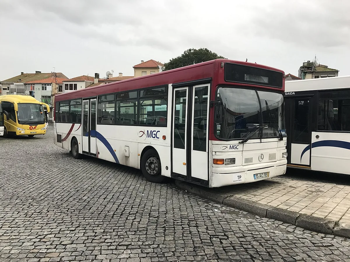 Local buses parked at an open-air Porto bus terminal